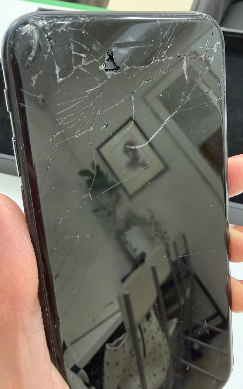 画面割れ修理前のiPhone。画面全体に大きなひび割れが広がっている。
